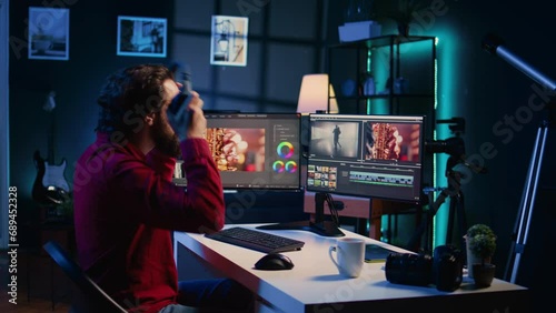 Videographer uses software to create visual effects for video projects while relaxing with some music. Professional wearing headphones using post production techniques to edit raw footage
