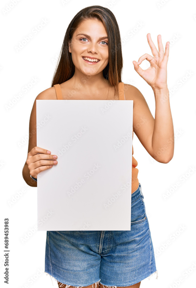 Young caucasian woman holding blank empty banner doing ok sign with fingers, smiling friendly gesturing excellent symbol Young caucasian woman holding blank empty banner doing ok sign with fingers, smiling friendly gesturing excellent symbol