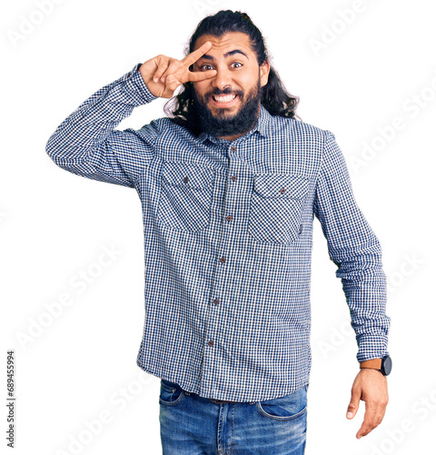 Young arab man wearing casual clothes doing peace symbol with fingers over face, smiling cheerful showing victory