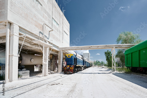 Locomotive moves cars across territory of silica plant