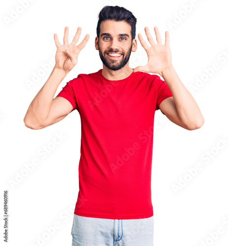 Young handsome man with beard wearing casual t-shirt showing and pointing up with fingers number nine while smiling confident and happy.