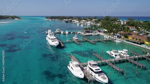 A 4K drone shot of the Bimini Blue Water Marina, in North Bimini, a small island chain found off the coast of the Bahamas. The camera rises and pulls away, revealing more of the island's landscape. photo
