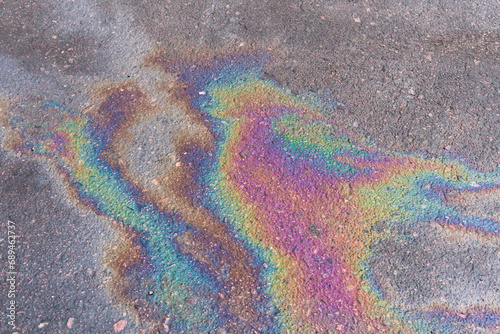 Textured stain of fuel or oil on wet asphalt on a rainy day