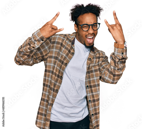 Young african american man with beard wearing casual clothes and glasses shouting with crazy expression doing rock symbol with hands up. music star. heavy music concept.