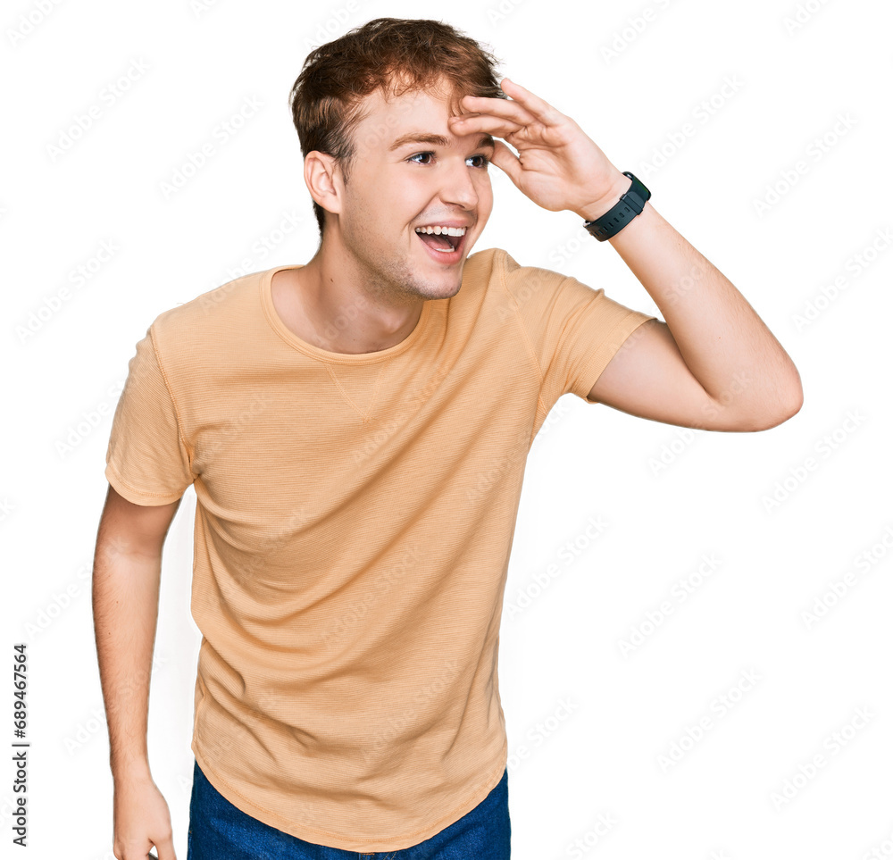 Young caucasian man wearing casual clothes very happy and smiling looking far away with hand over head. searching concept. Young caucasian man wearing casual clothes very happy and smiling looking far away with hand over head. searching concept.
