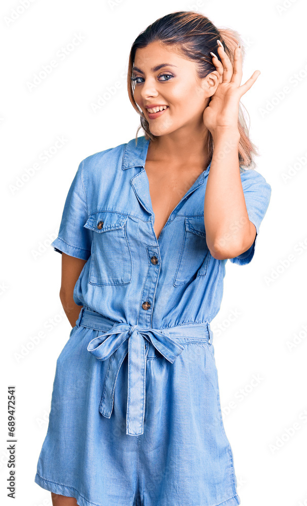 Young beautiful woman wearing casual clothes smiling with hand over ear listening an hearing to rumor or gossip. deafness concept. Young beautiful woman wearing casual clothes smiling with hand over ear listening an hearing to rumor or gossip. deafness concept.