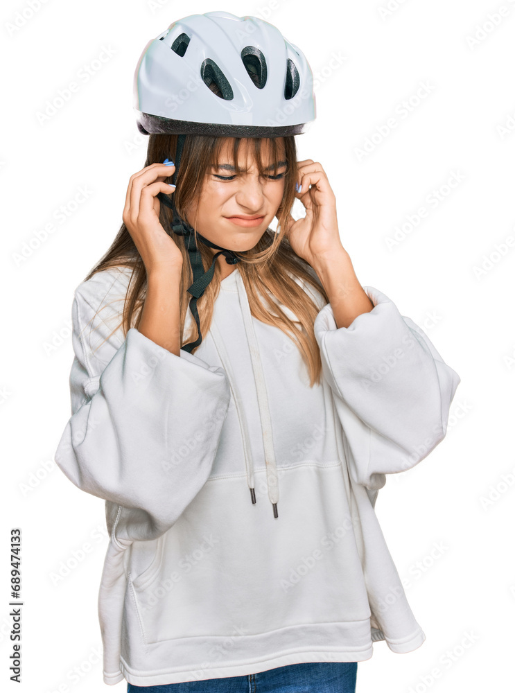 Teenager caucasian girl wearing bike helmet covering ears with fingers with annoyed expression for the noise of loud music. deaf concept. Teenager caucasian girl wearing bike helmet covering ears with fingers with annoyed expression for the noise of loud music. deaf concept.