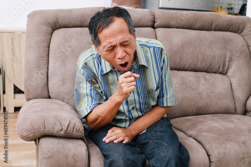 Old asian man get a cold and cough at home photo