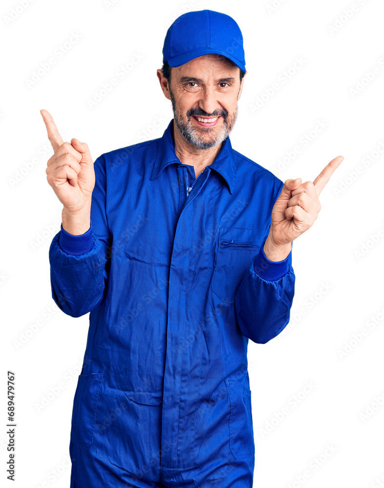 Middle age handsome man wearing mechanic uniform smiling confident pointing with fingers to different directions. copy space for advertisement