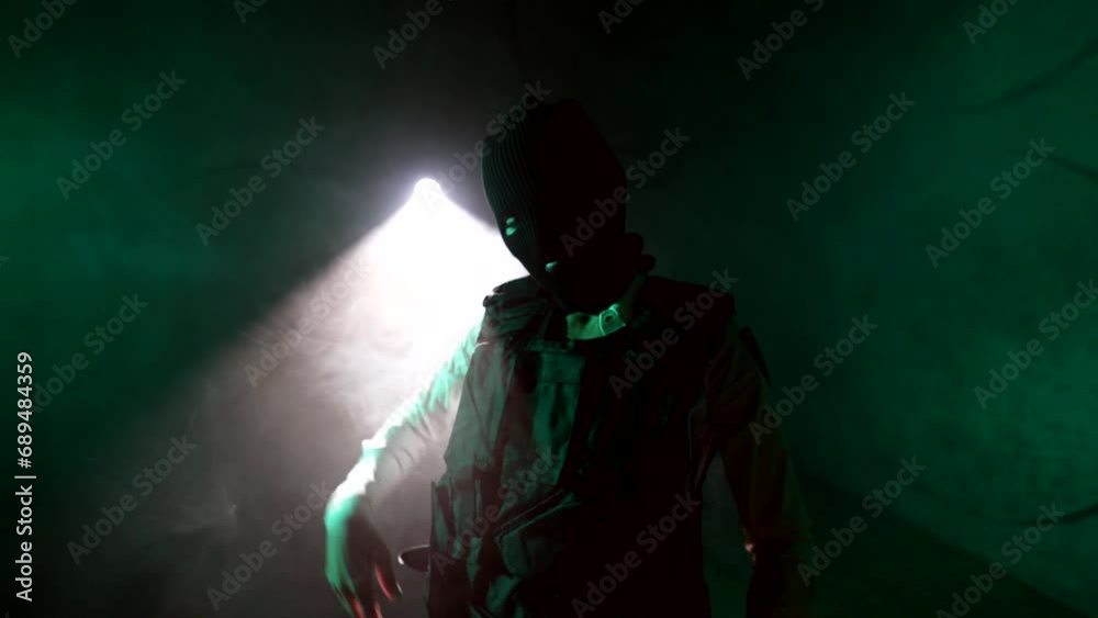 portrait of woman soldier or gangster in body armor and balaclava standing alone in dark basement portrait of woman soldier or gangster in body armor and balaclava standing alone in dark basement