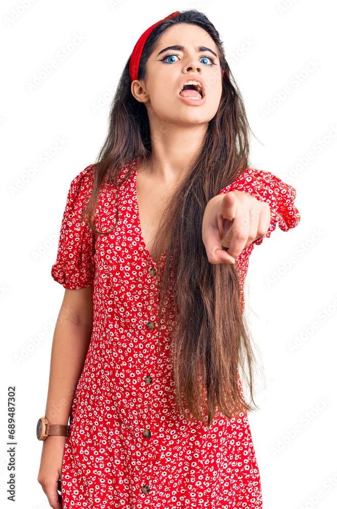 Brunette teenager girl wearing summer dress pointing displeased and frustrated to the camera, angry and furious with you Brunette teenager girl wearing summer dress pointing displeased and frustrated to the camera, angry and furious with you