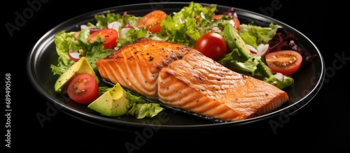 Grilled salmon with lettuce, tomato, and avocado salad.