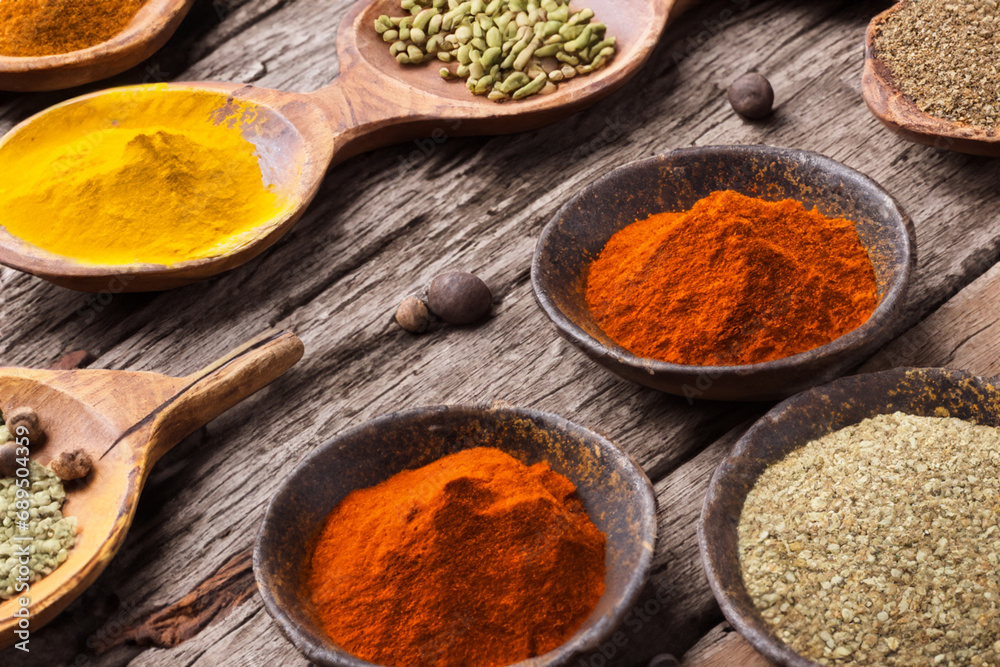 Spices and herbs in wooden bowls and spoons. Food and cooking ingredients. Spices and herbs in wooden bowls and spoons. Food and cooking ingredients.