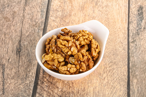 Cracked unshelled walnut in the bowl