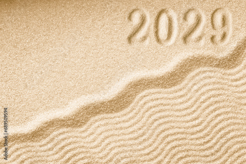 Imprints of numbers 2029 new year on a golden sand waves