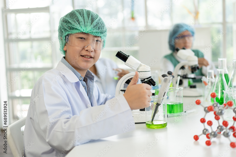 Asia kid boy in science uniform funny learning study science of use microscope and test chemical Asia kid boy in science uniform funny learning study science of use microscope and test chemical