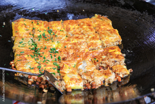 Chinese food specialty - tofu skin (Doupi) in hot wok. It is a kind of omlet made of glutinous rice with egg, mince and other ingredients. It is a favorite breakfast in Wuhan, China. photo