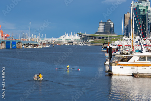 Kayakers Glide Past Yachts in Bustling Harbor Cityscape