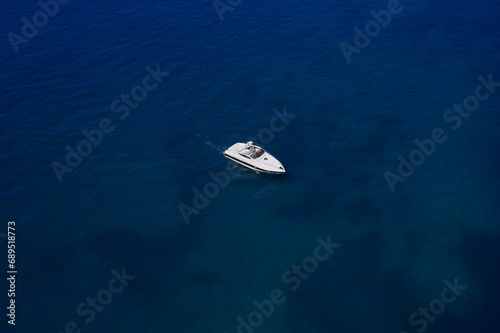 Fototapeta Naklejka Na Ścianę i Meble -  Large white boat with people on dark blue water, top view.