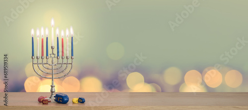 Hanukkah Chanukah Jewish holiday background with menorah (Judaism candelabra candlestick) Hebrew Festival of Lights, Feast of Dedication with burning candle candlelight bokeh and traditional Dreidrel  photo
