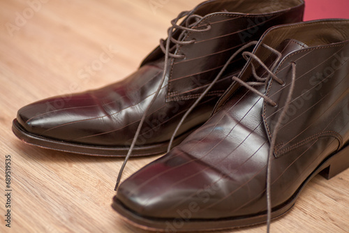 This image captures a pair of classic brown leather dress shoes with a sophisticated sheen. The intricate detailing of the shoes' construction, including the fine stitching and the elegant design of