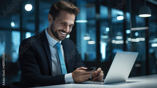 A male businessman works on a laptop in a modern office