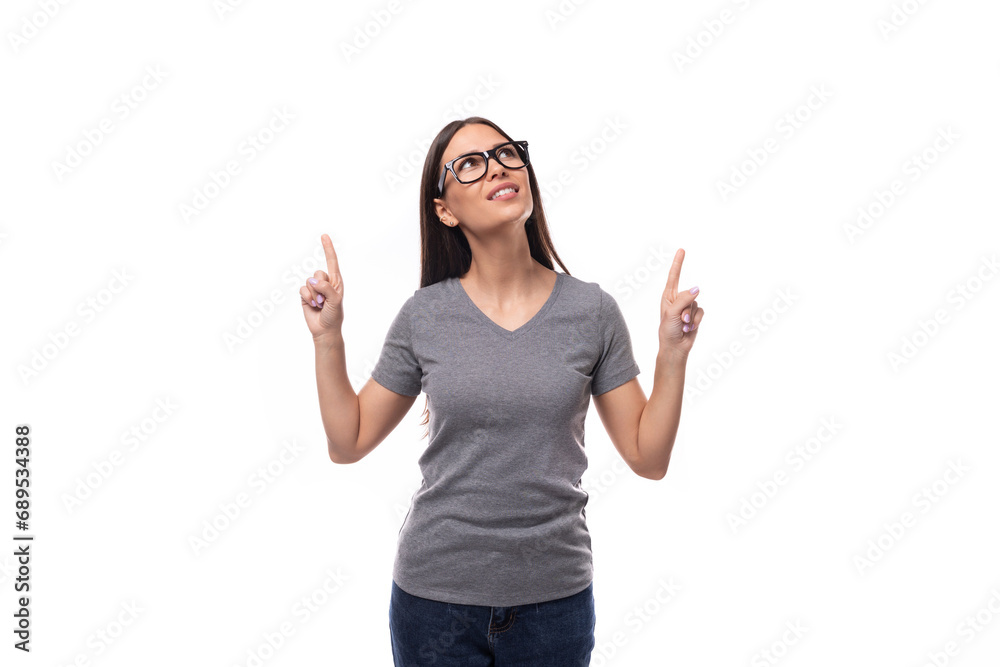 pretty brunette leader woman dressed in a gray t-shirt tells interesting news on a white background
