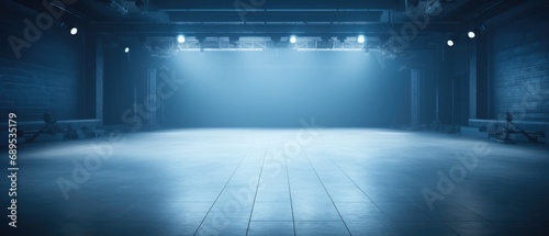 Empty modern theater stage with blue lighting and smoky atmosphere. Performance and entertainment background.