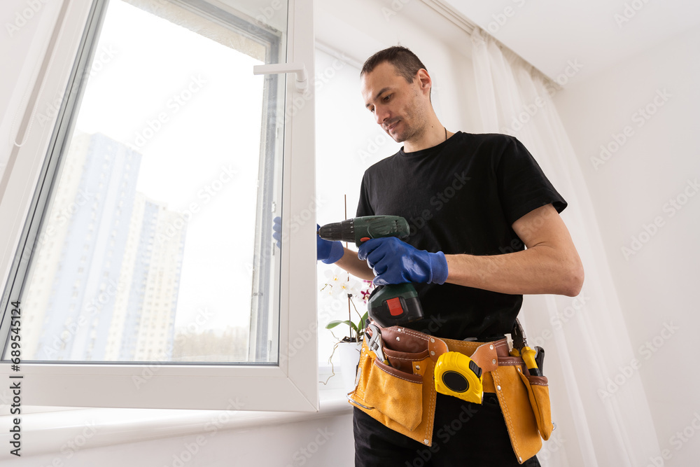 Master in gloves adjusting pvc windows with screwdriver closeup. Installation of plastic windows repair and maintenance concept