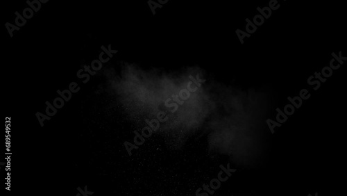White powder explosion on black background.Impact dust particles. Dust explosion in front of black background, slow-motion close up. photo