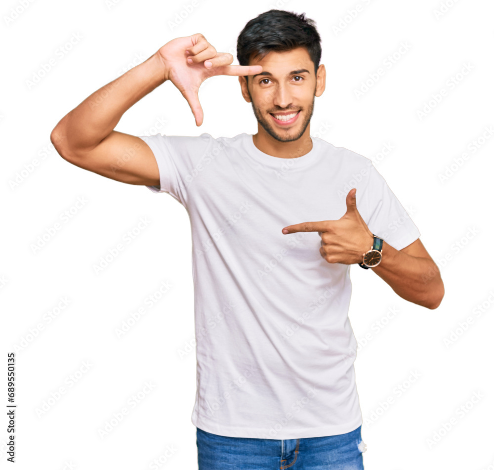 Young handsome man wearing casual white tshirt smiling making frame with hands and fingers with happy face. creativity and photography concept. Young handsome man wearing casual white tshirt smiling making frame with hands and fingers with happy face. creativity and photography concept.