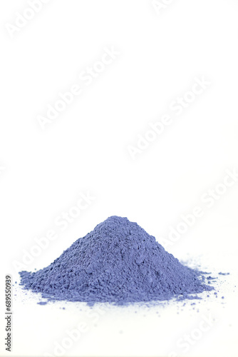 Blue matcha powder from clitoria flowers on a white background. Vertical orientation.
