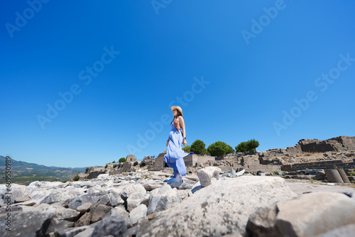 Lifestyle, Asian woman tourist take a holiday for travel in summer at Acropolis of Pergamon Ancient Greek City, Landmark of Tourism Turkiye, Izmir, Turkey. She is stand wind and enjoy relax vacation.. photo