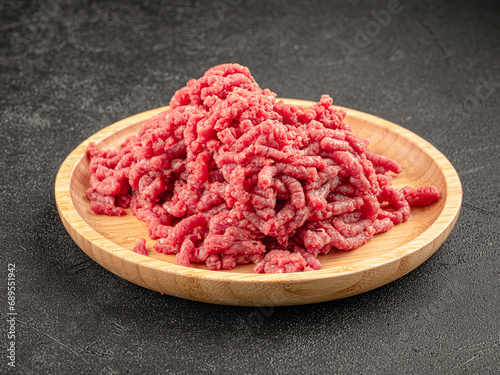 Plate of raw minced beef fillet on grey background