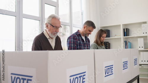 Citizens are voting at the polling place, casting their votes on ballots during elections day
