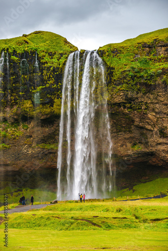 Seljalandsfoss  Iceland  one of the biggest waterfall in Iceland Seljalandsfoss. Beautiful Icelandic landscape  huge cliff  dramatic sky and tourists
