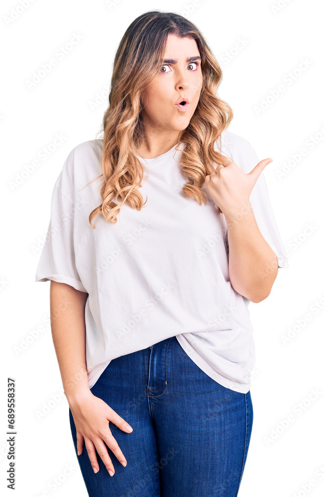 Young caucasian woman wearing casual clothes surprised pointing with hand finger to the side, open mouth amazed expression. Young caucasian woman wearing casual clothes surprised pointing with hand finger to the side, open mouth amazed expression.