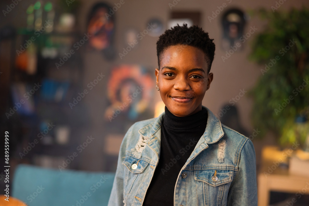 Portrait of delighted afro american woman with short dark hair smiling at camera confidentely staying in the beautiful cozy living room. Portrait of delighted afro american woman with short dark hair smiling at camera confidentely staying in the beautiful cozy living room.