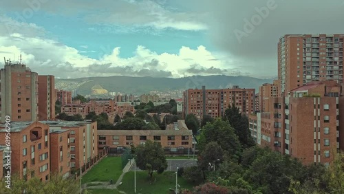 A drone flying amidst buildings with a mountain in the background photo