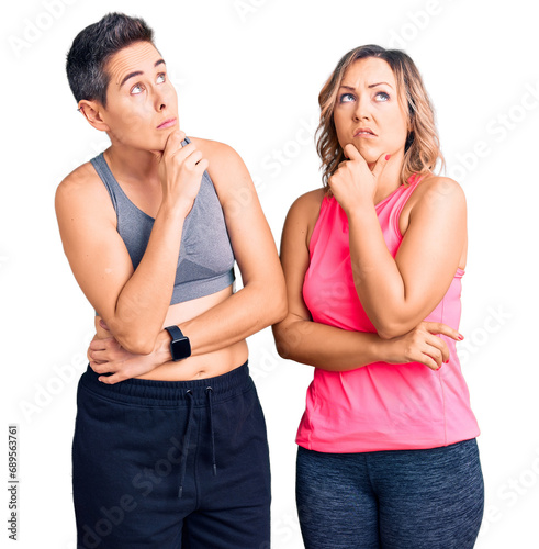 Couple of women wearing sportswear thinking worried about a question, concerned and nervous with hand on chin