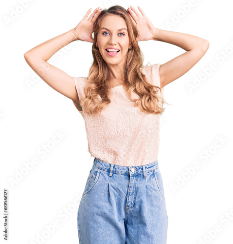 Young beautiful caucasian woman with blond hair wearing casual clothes smiling cheerful playing peek a boo with hands showing face. surprised and exited