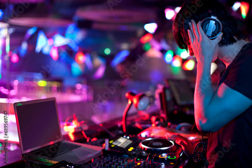 Chinese DJ doing record scratching in nightclub photo