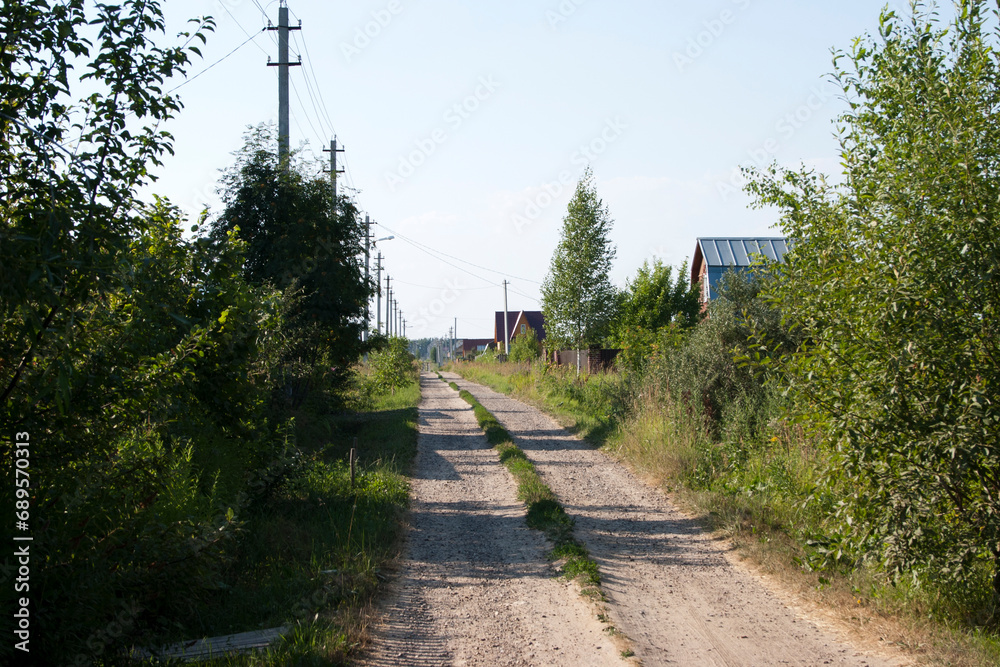 Country road through the village in summer. Russia, near Moscow
