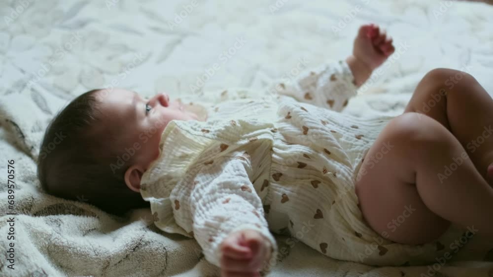 A baby lies comfortably as a caring hand offers a bottle, an image of nurturing and sustenance. It s a moment of peaceful care.