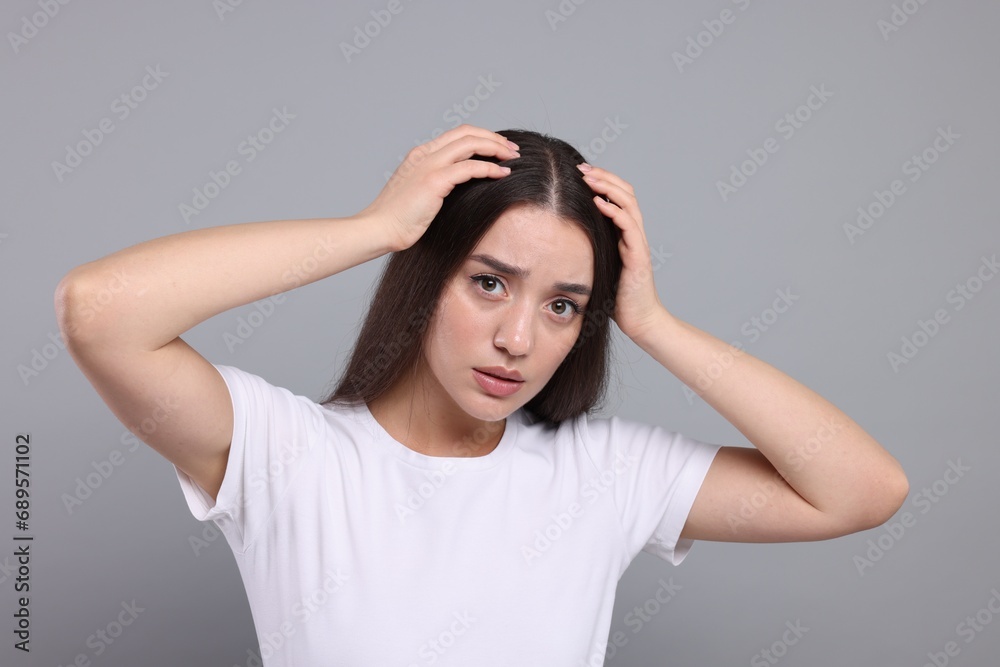 Emotional woman with healthy hair on grey background. Dandruff problem Emotional woman with healthy hair on grey background. Dandruff problem