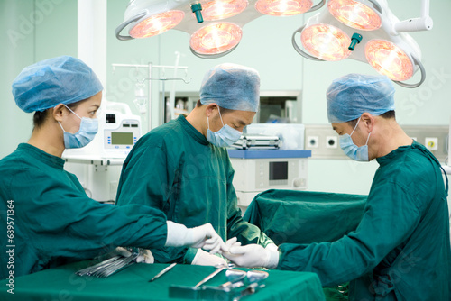 Three surgeons in an operating room photo