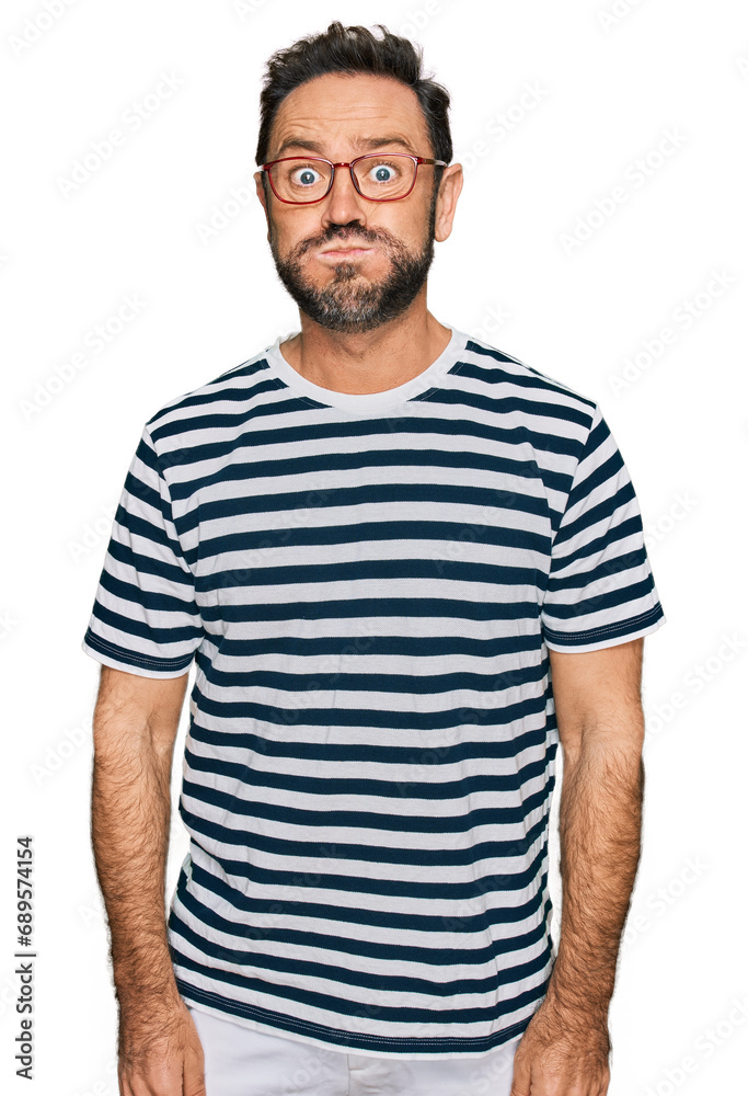Middle age man wearing casual clothes and glasses puffing cheeks with funny face. mouth inflated with air, crazy expression. Middle age man wearing casual clothes and glasses puffing cheeks with funny face. mouth inflated with air, crazy expression.