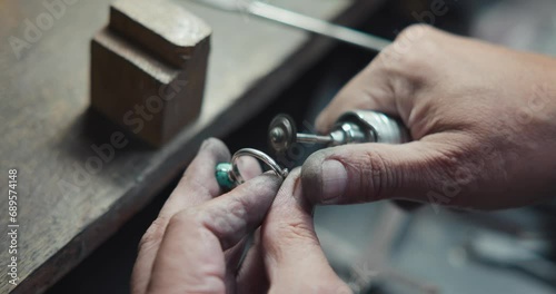 Jeweler in the process of hand-making a blue quartz jewelry ring at jewlery workshop photo