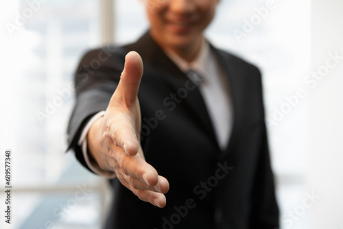 Businessman In Office Reaching Out To Shake Hands photo
