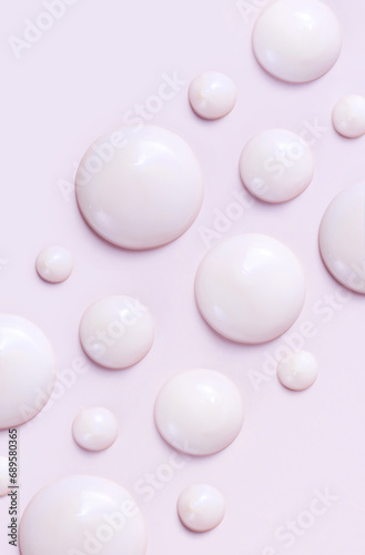 cosmetic smears drops of cream texture on pastel pink background